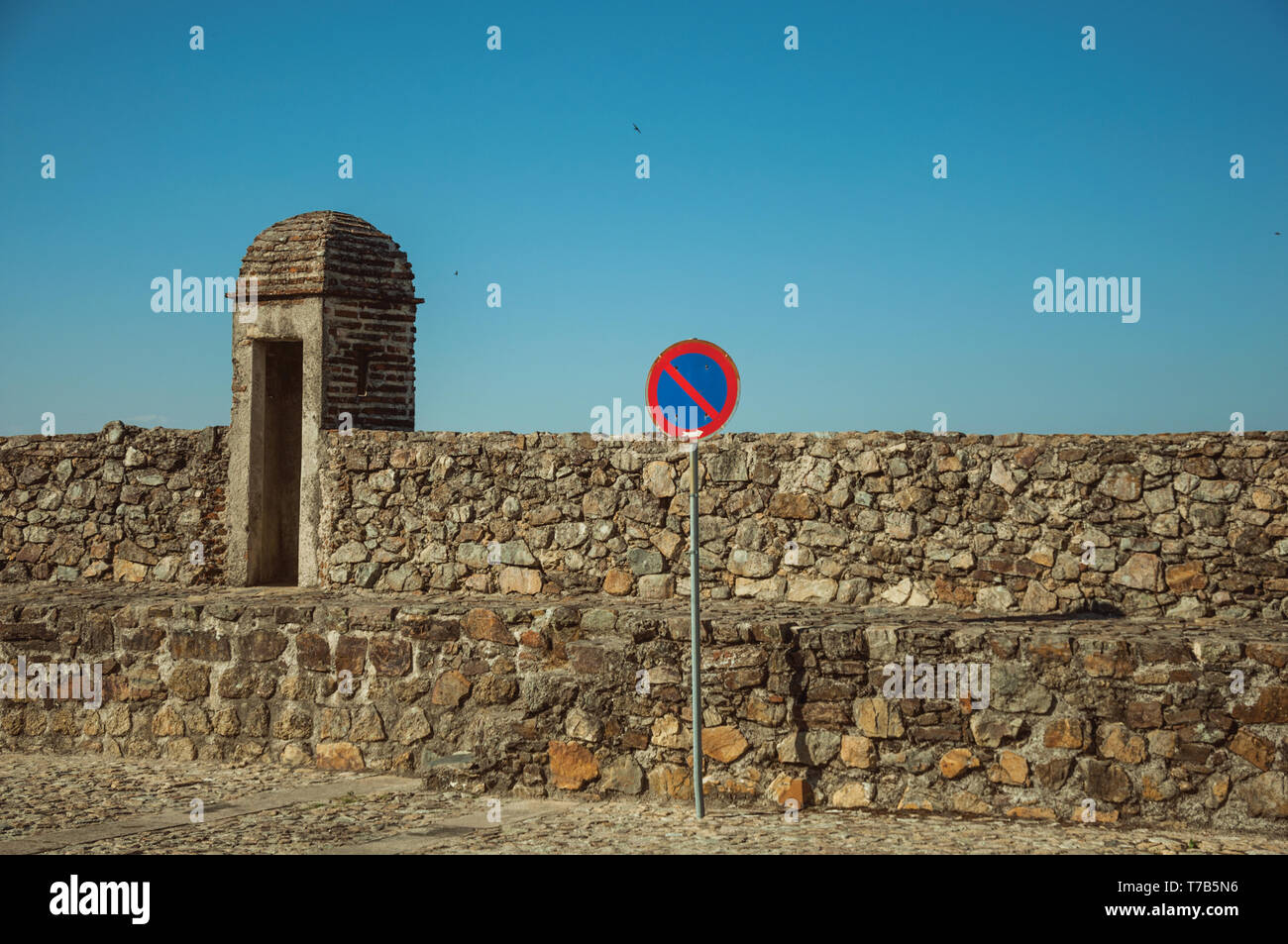 Pas d'attente road sign in front of mur épais fait de pierres brutes avec petite tour de guet à Marvao. Un hameau médiéval perché sur un rocher au Portugal. Banque D'Images