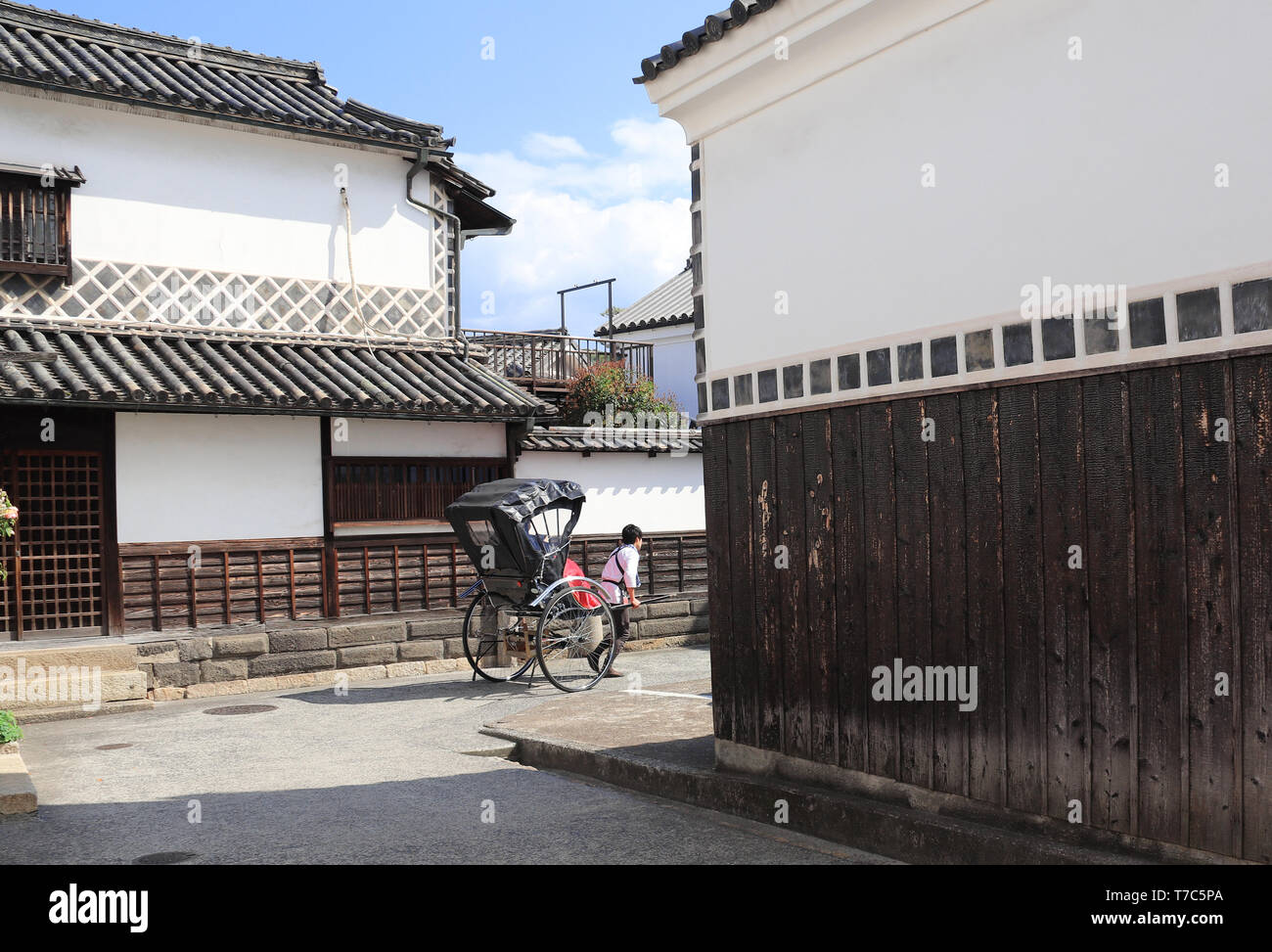 Pousse-pousse sur la rue médiévale avec des maisons japonaises traditionnelles et des entrepôts de district, Kurashiki Bikan City, Japon Banque D'Images