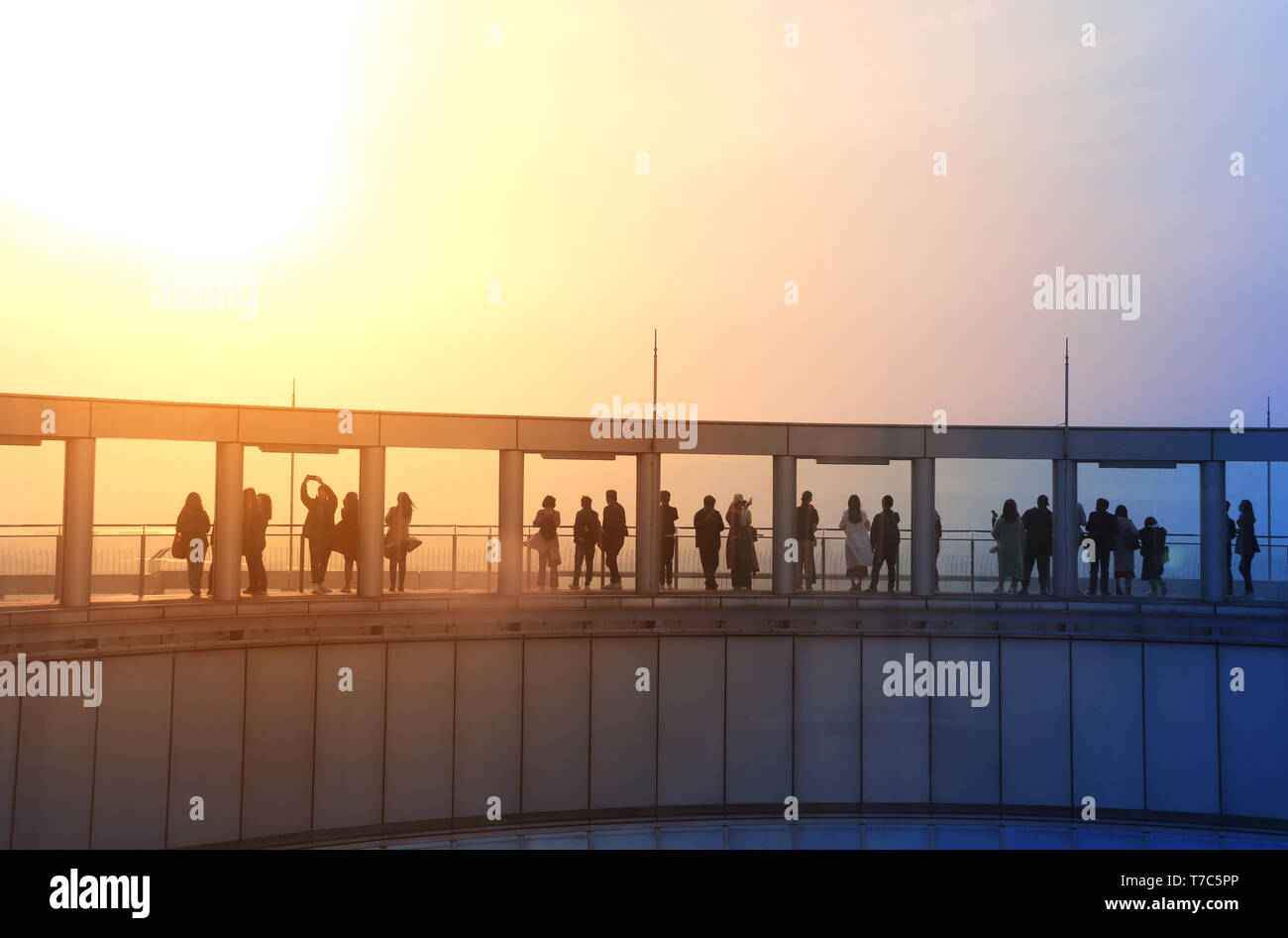 Les gens sur le pont d'observation du ciel Umeda, à Osaka, au Japon. Silhouettes sur fond de ciel coucher de soleil. Les tons de la photo en couleurs bleu et orange Banque D'Images
