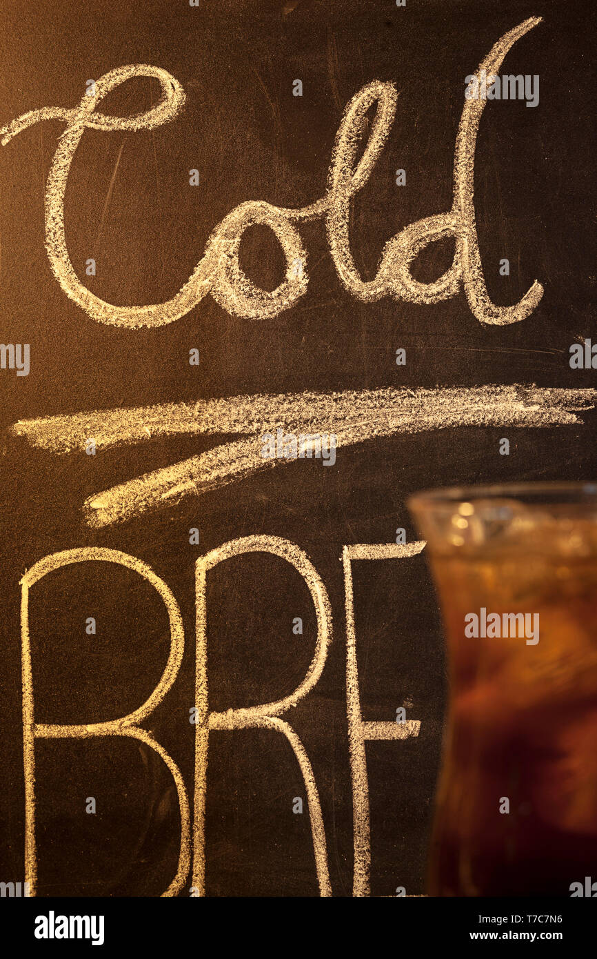 Café froid avec écriture sur tableau de craie en arrière-plan. Banque D'Images