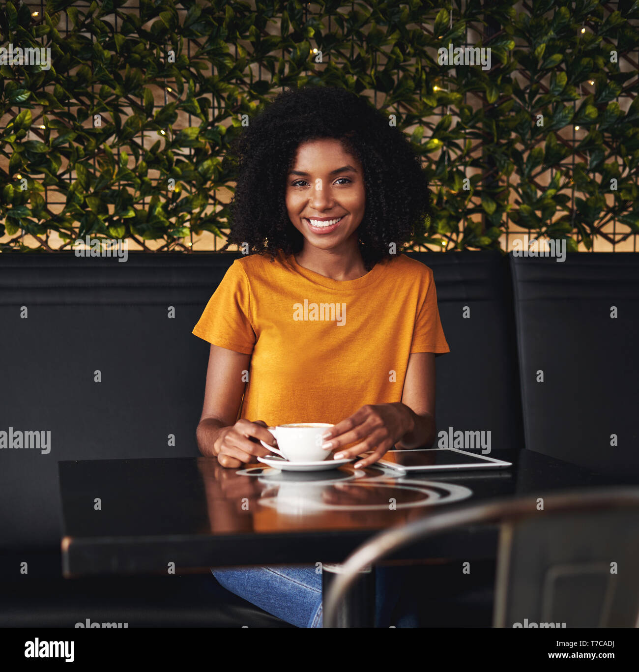 Portrait of a smiling young woman sitting in cafe Banque D'Images