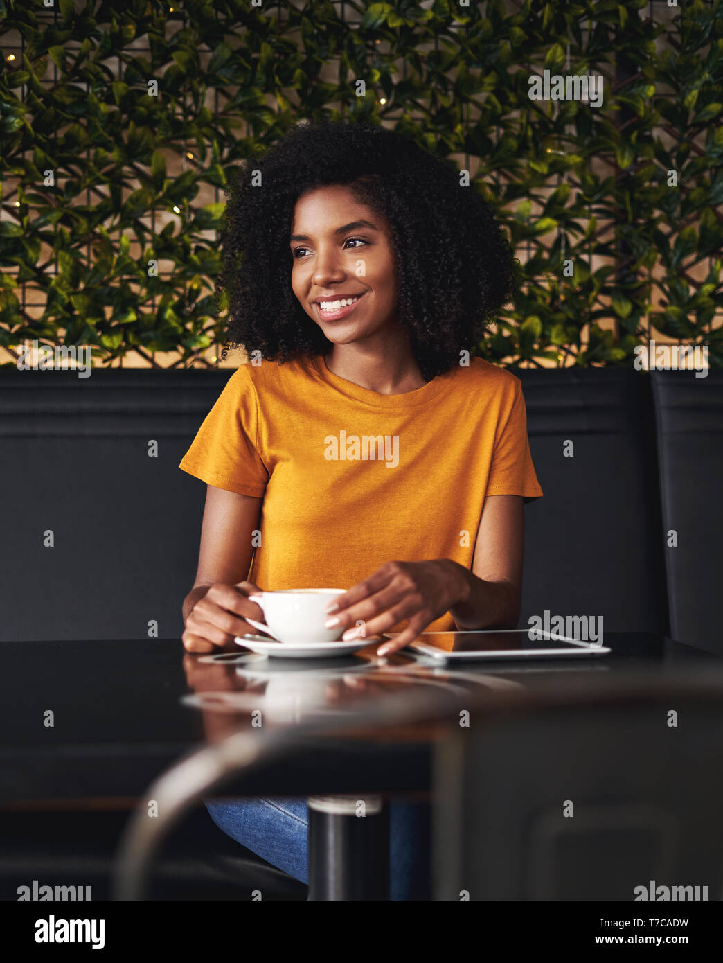 Smiling young woman sitting in cafe Banque D'Images