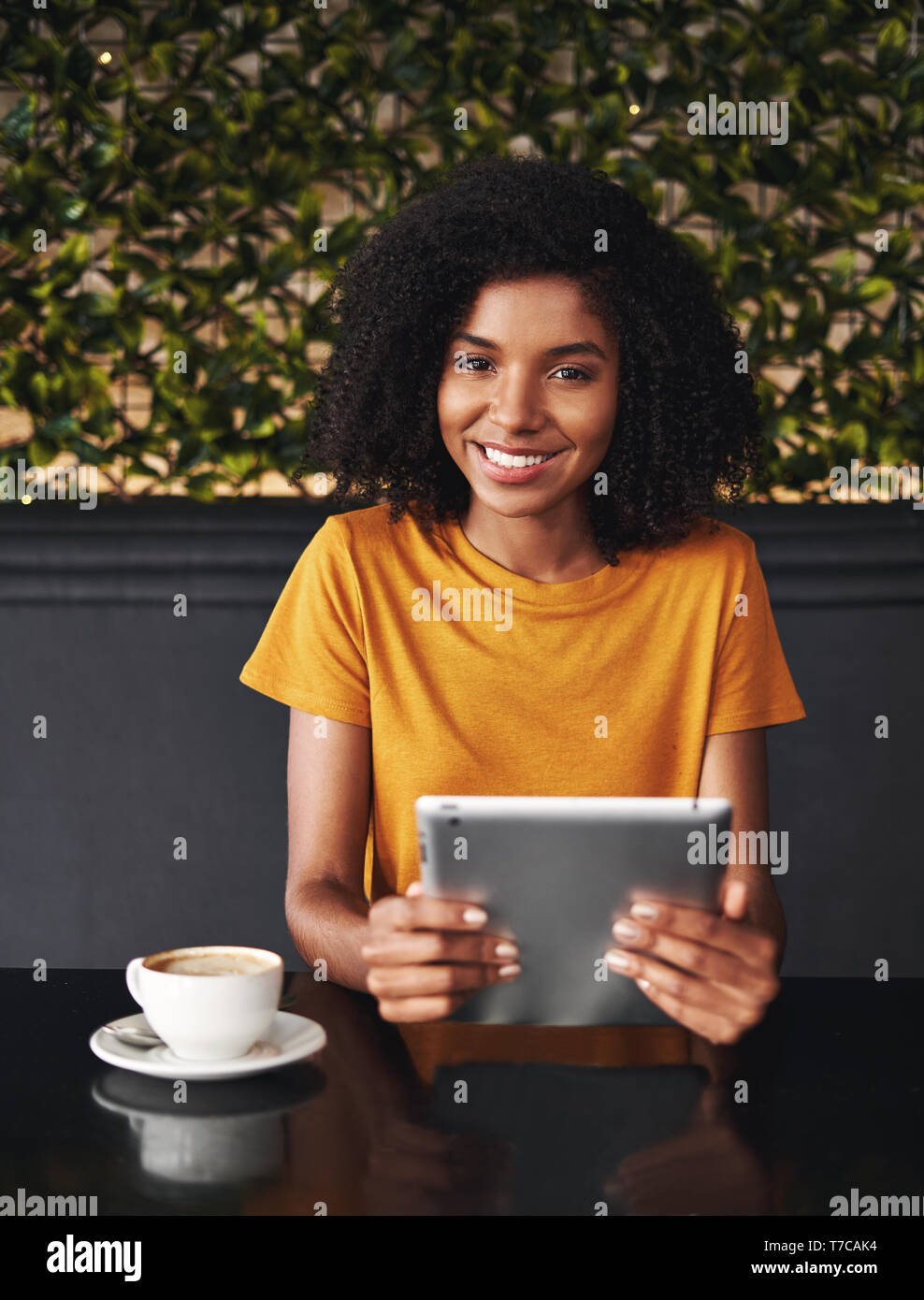 Smiling young woman holding digital tablet in hand Banque D'Images