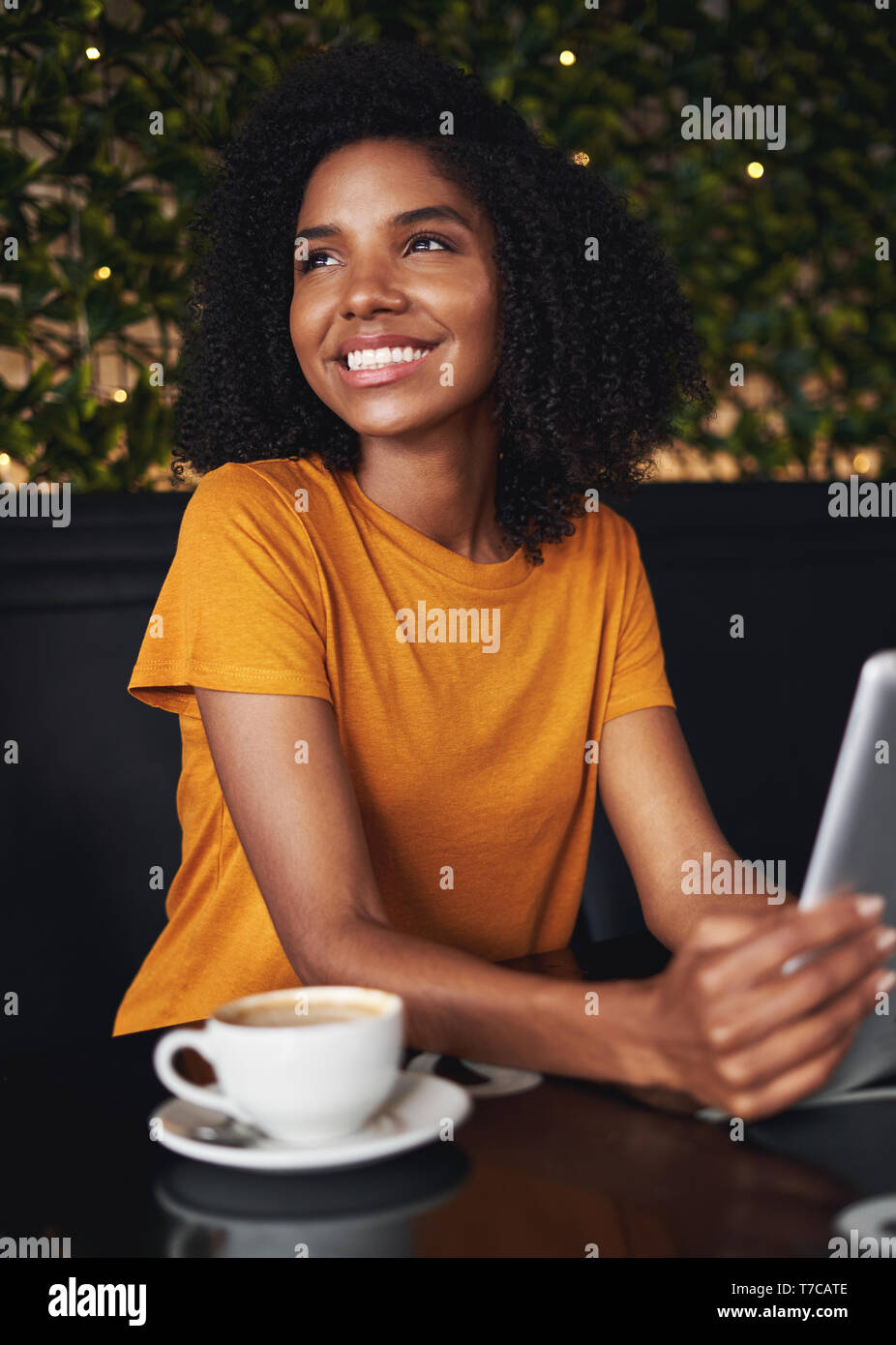 Smiling young woman in cafe looking away Banque D'Images