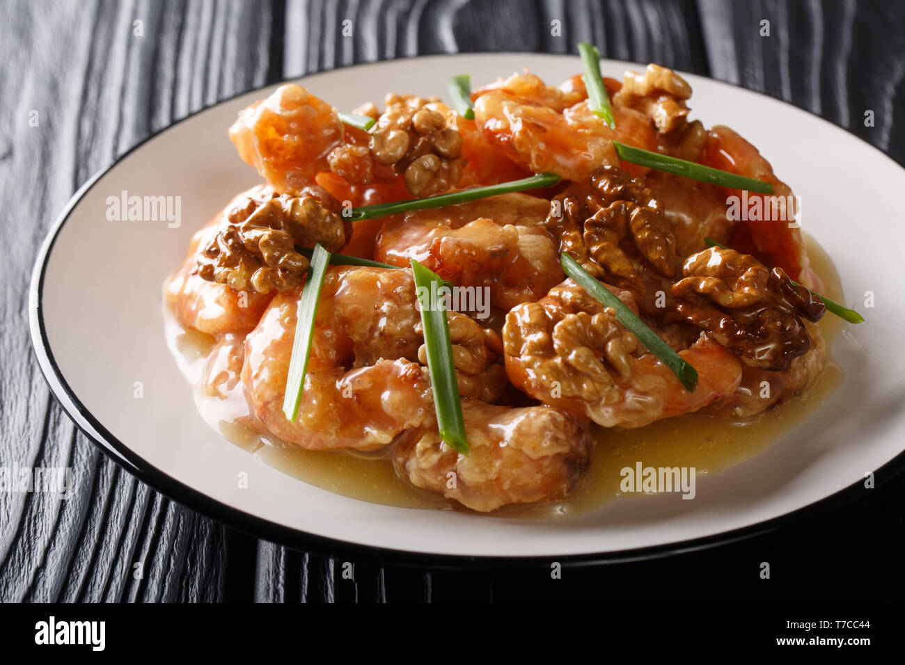 Crevettes croustillantes au miel, noix confites, et doux mayo close-up sur une plaque horizontale. Banque D'Images