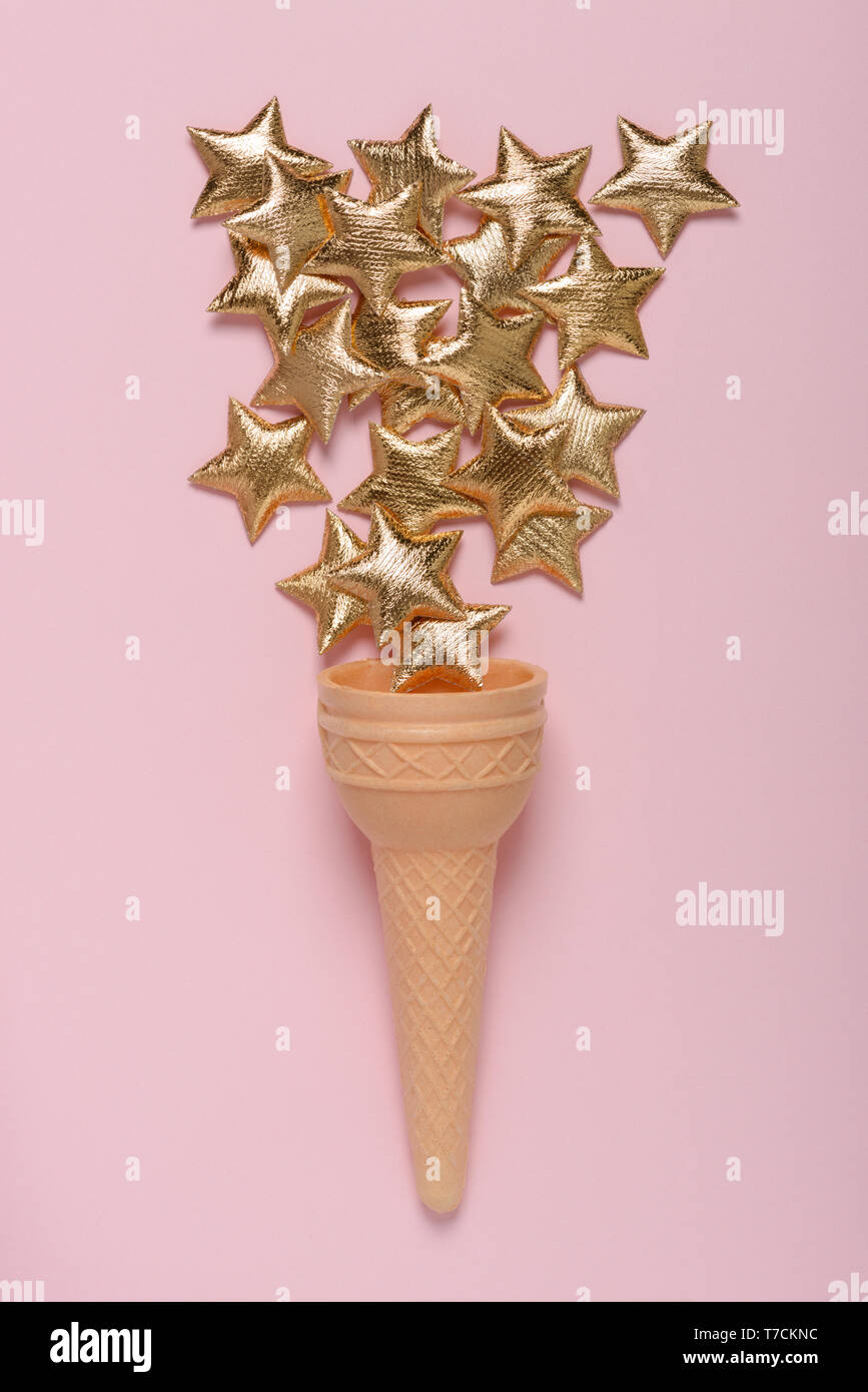 Ice cream sweet wafer cone avec brillant or étoile sur rose pastel arrière-plan flatlay Banque D'Images