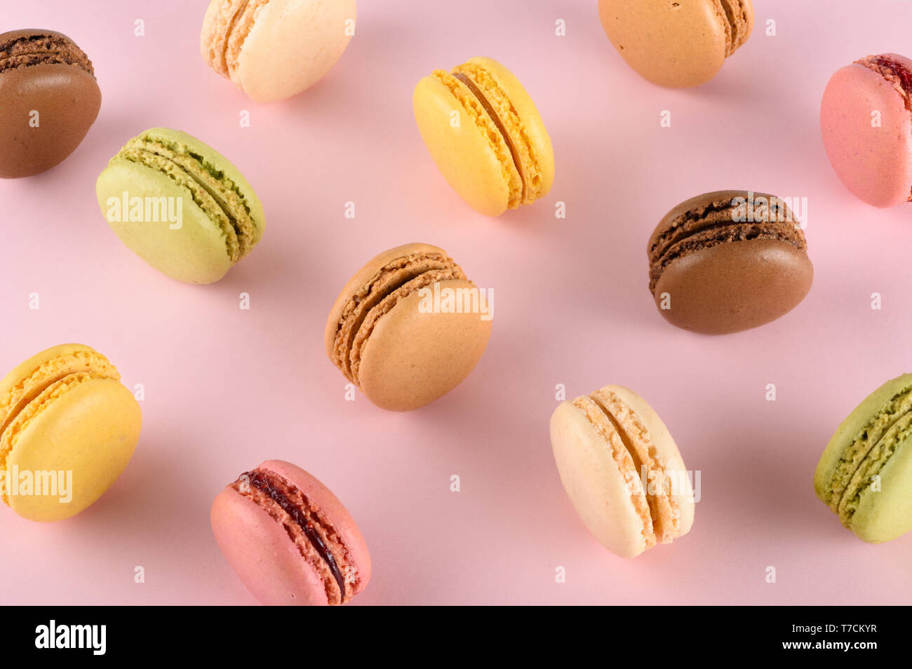 Classic original français colorés macarons assortiment avec des goûts différents sur rose pastel arrière-plan Banque D'Images