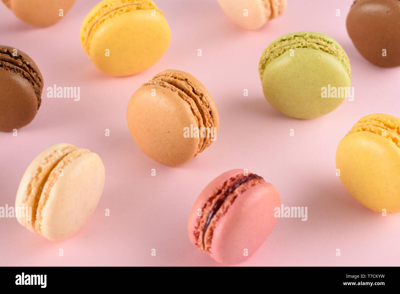 Macarons sur fond pastel. Macarons français classique avec des goûts différents. Banque D'Images