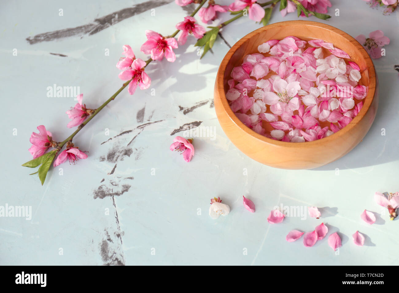 Bol en bois avec de l'eau et de fleurs sur la table Banque D'Images