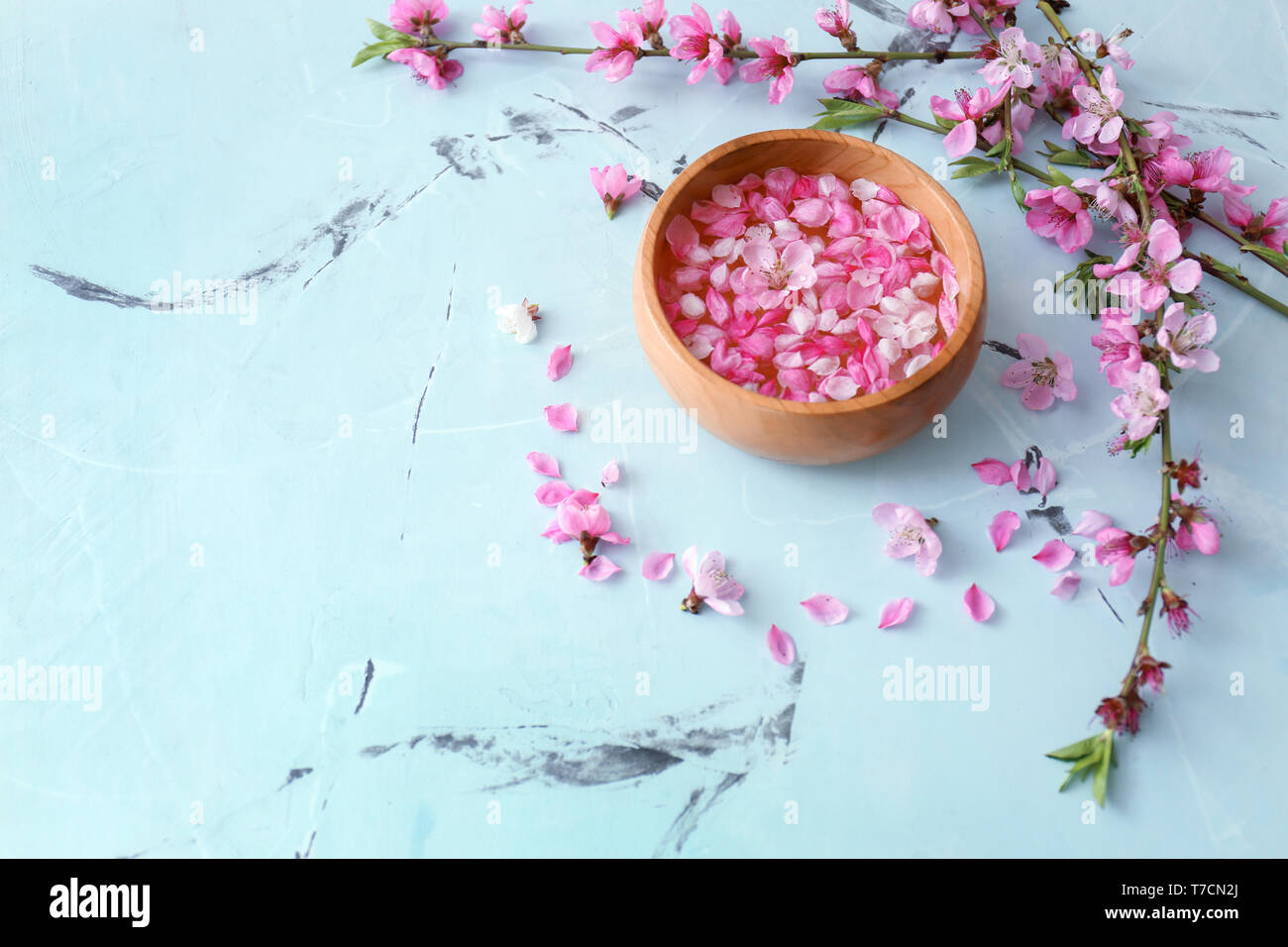 Bol en bois avec de l'eau et de fleurs sur la table Banque D'Images