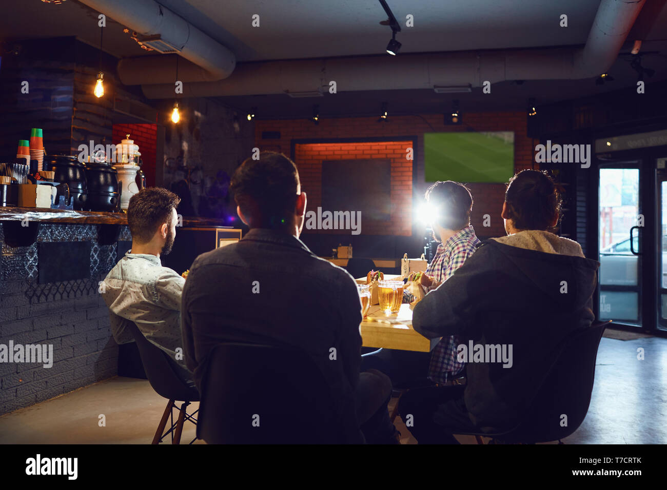 Amis dans le bar des sports de regarder la télévision. Banque D'Images