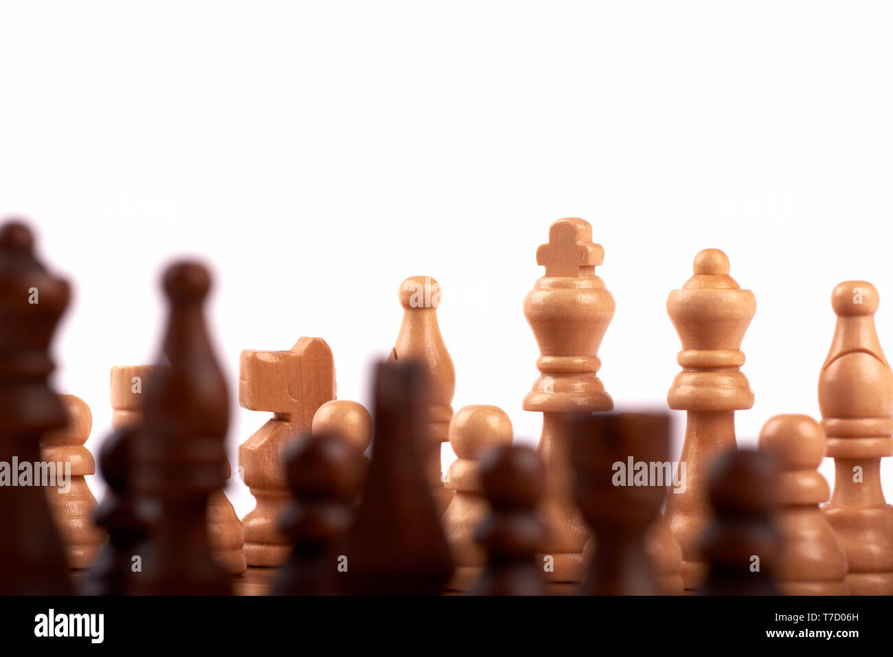 Pièces des échecs en bois dans un duel sur un échiquier. Roi, Dame et shooter avec cheval. Des problèmes de mise au point de l'équipe des ennemis. Isolé sur fond blanc Banque D'Images