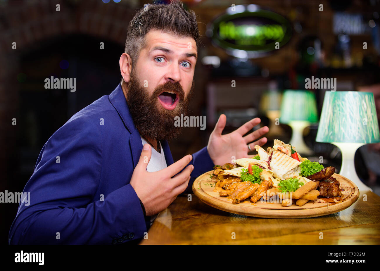 Woman costume formel s'asseoir au restaurant. L'homme a reçu de pommes de terre frites repas avec les bâtonnets de poisson viande. Il méritent de délicieux repas. Profitez de votre repas. Des calories. Vous pourrez vous détendre après une dure journée. La nourriture délicieuse. Banque D'Images
