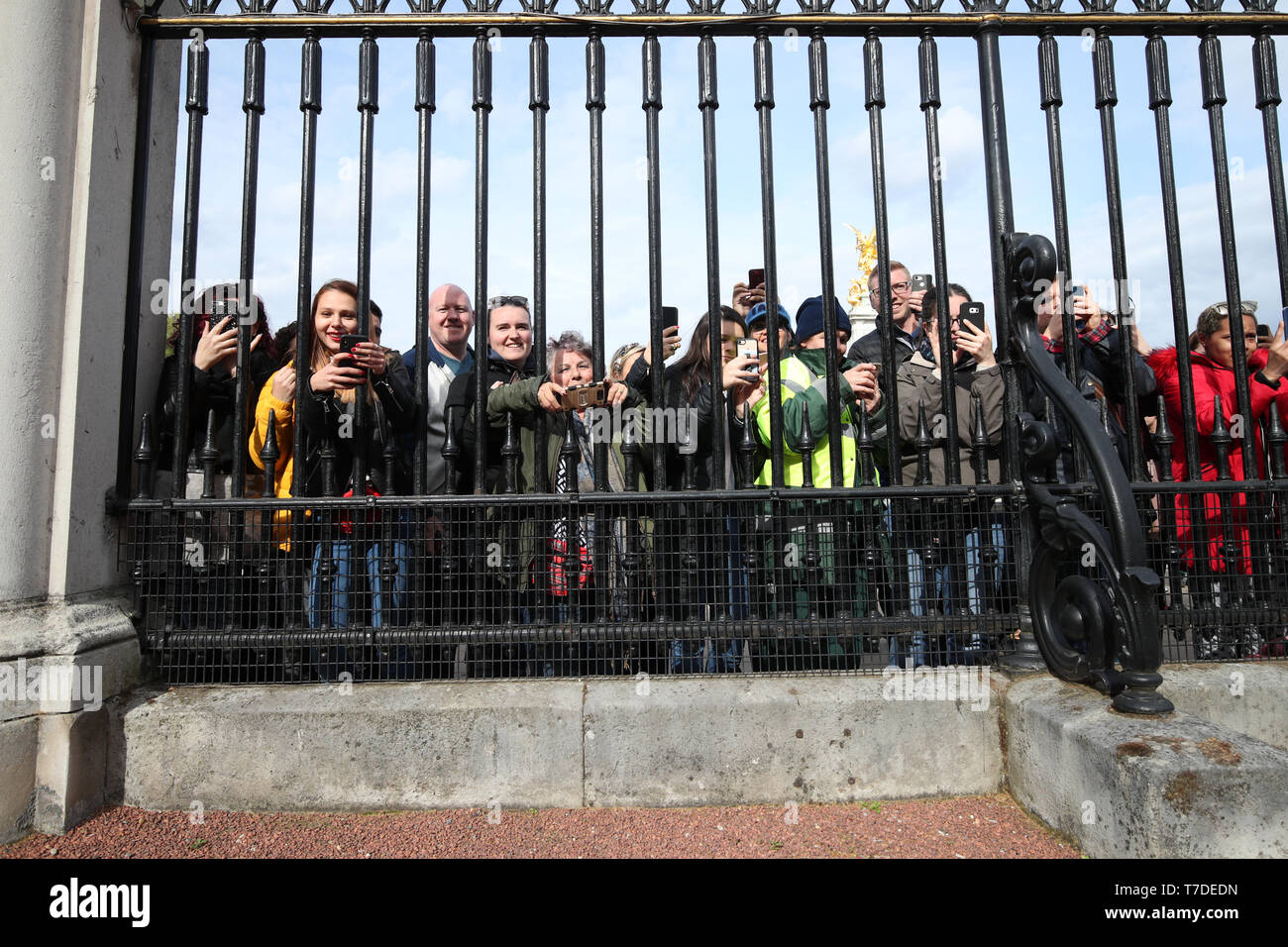 Les gens se rassemblent à l'extérieur de Buckingham Palace pour prendre des photos sur leurs téléphones portables de l'avis placé sur un chevalet dans l'avant-cour du palais à Londres pour annoncer officiellement la naissance d'un bébé garçon pour le duc et la duchesse de Cambridge. Banque D'Images