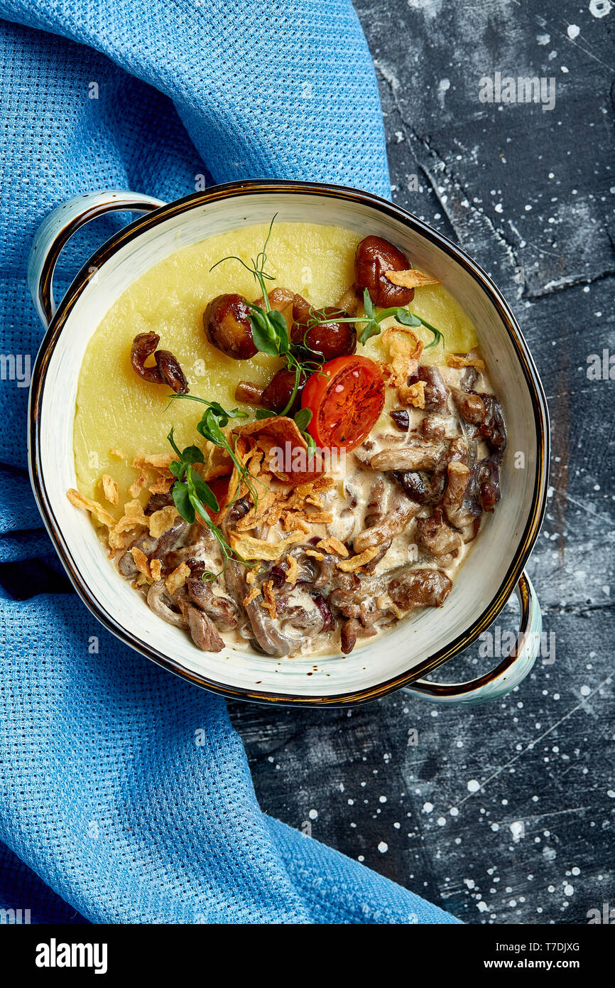 Bœuf stroganoff avec de la purée de pommes de terre dans un pot. Vue de dessus, l'arrière-plan en pierre Banque D'Images