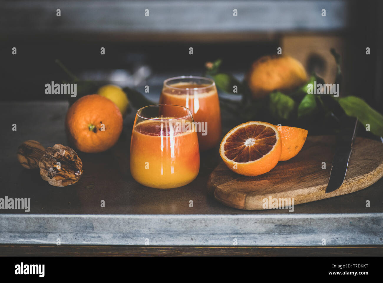 Verres de jus d'orange fraîchement pressé ou sang smoothie sur le béton dans la cuisine. Mode de vie sain, végétarien, végétalien, régime alcalin, le ressort de Banque D'Images