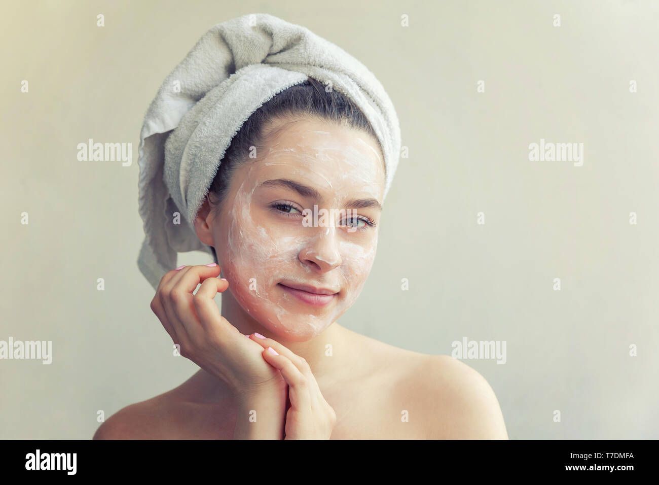 Portrait of woman in towel on head avec blanc masque nourrissant ou la crème sur le visage, fond blanc isolé. Soin visage bio eco nettoyage cosme Banque D'Images