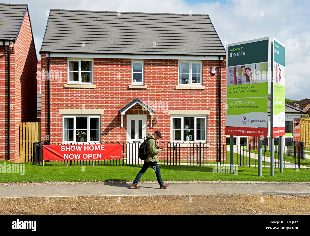 Man Walking cours des maisons dans le Mile, un développement de nouveaux logements par Persimmon Homes, près de Pickering, East Yorkshire, England UK Banque D'Images