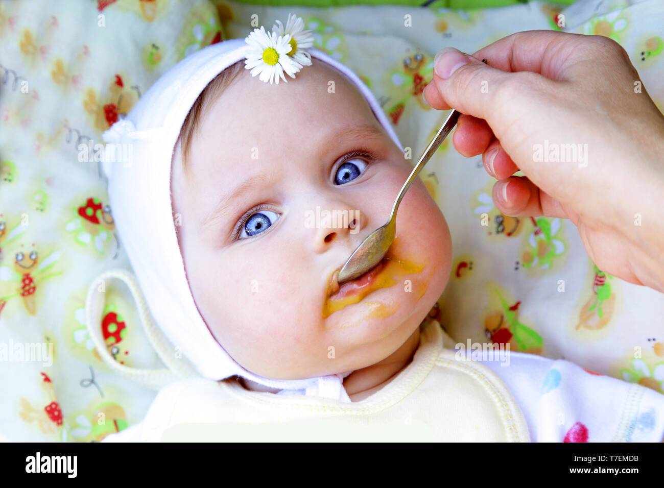 Belle petite fille manger premier repas solide purée de potiron Banque D'Images