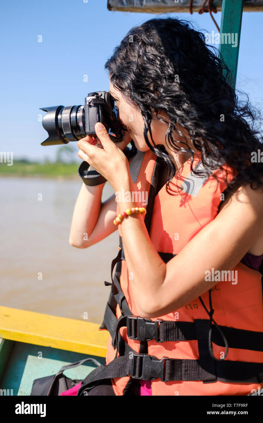 Jeune femme blanc portant un gilet de prendre des photos en allant sur un  bateau sur la rivière Madre de Dios, rivière, bassin de l'Amazone, au Pérou  Photo Stock - Alamy