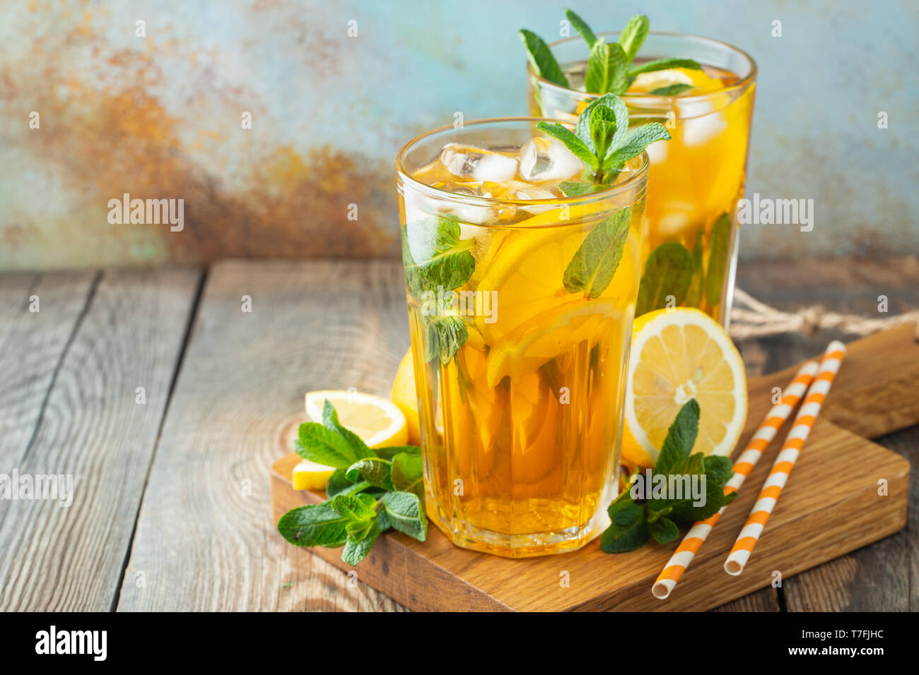Thé glacé traditionnel avec du citron et de la glace dans des grands verres sur une table rustique en bois. Avec l'exemplaire de l'espace. Banque D'Images