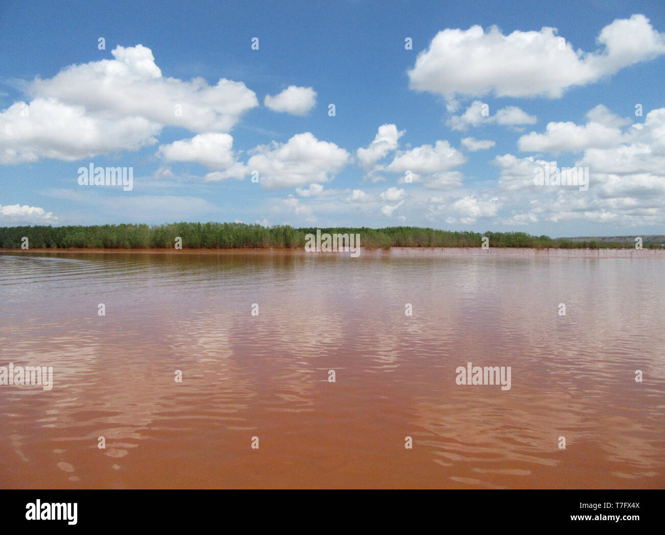 Ciel bleu avec des nuages blancs sur le fleuve Betsiboka dans le delta du nord de Madagascar. La rivière est de couleur rouge en raison de l'érosion du sol. Banque D'Images