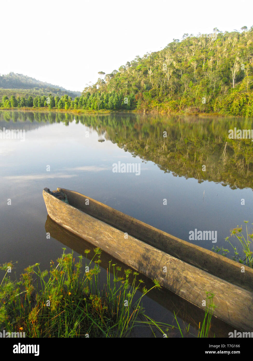 Bateau en bois reposant le long du rivage dans un lac naturel près de Parc National Parc Mantadia- Andasibe (Périnet), Madagascar, sur un beau matin serein. Banque D'Images