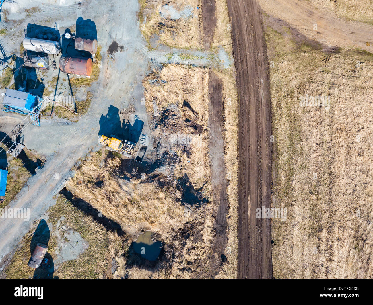 Vue aérienne d'un excavateur et tracteur jaune du transport de la pierre concassée, du ciment et du sable pendant l'extraction de minéraux à partir de la terre pour le co Banque D'Images