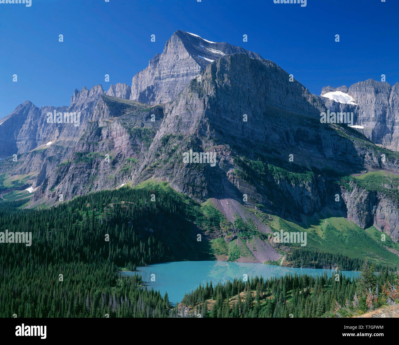 USA, Montana, Glacier National Park, Mount Gould et Angel tour d'aile au-dessus de Grinnell Lac qui est colorée par le limon glaciaire. Banque D'Images
