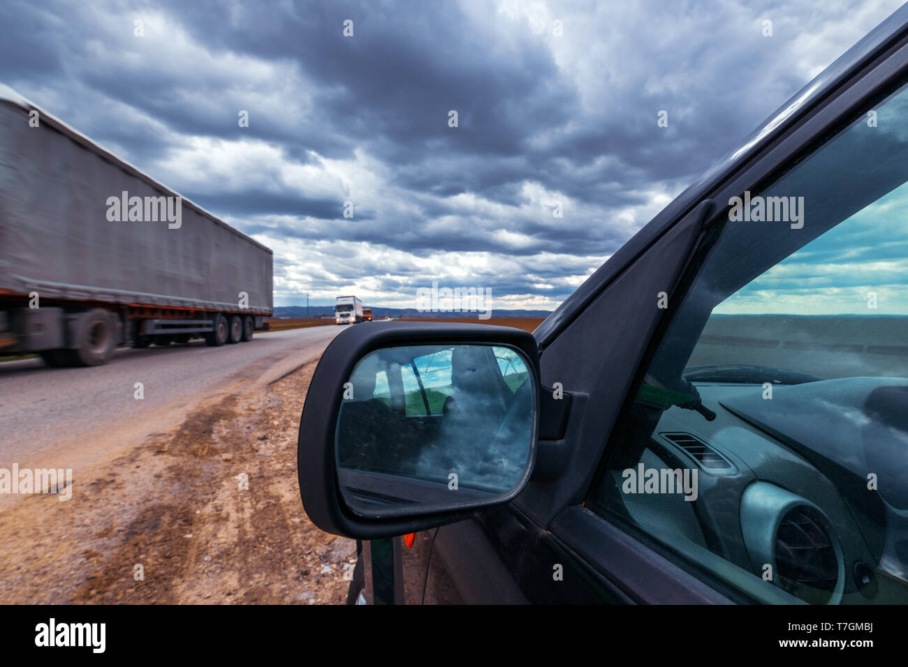 Broken voiture s'est arrêtée par la route le jour de tempête, dramatique nuages sur le ciel Banque D'Images