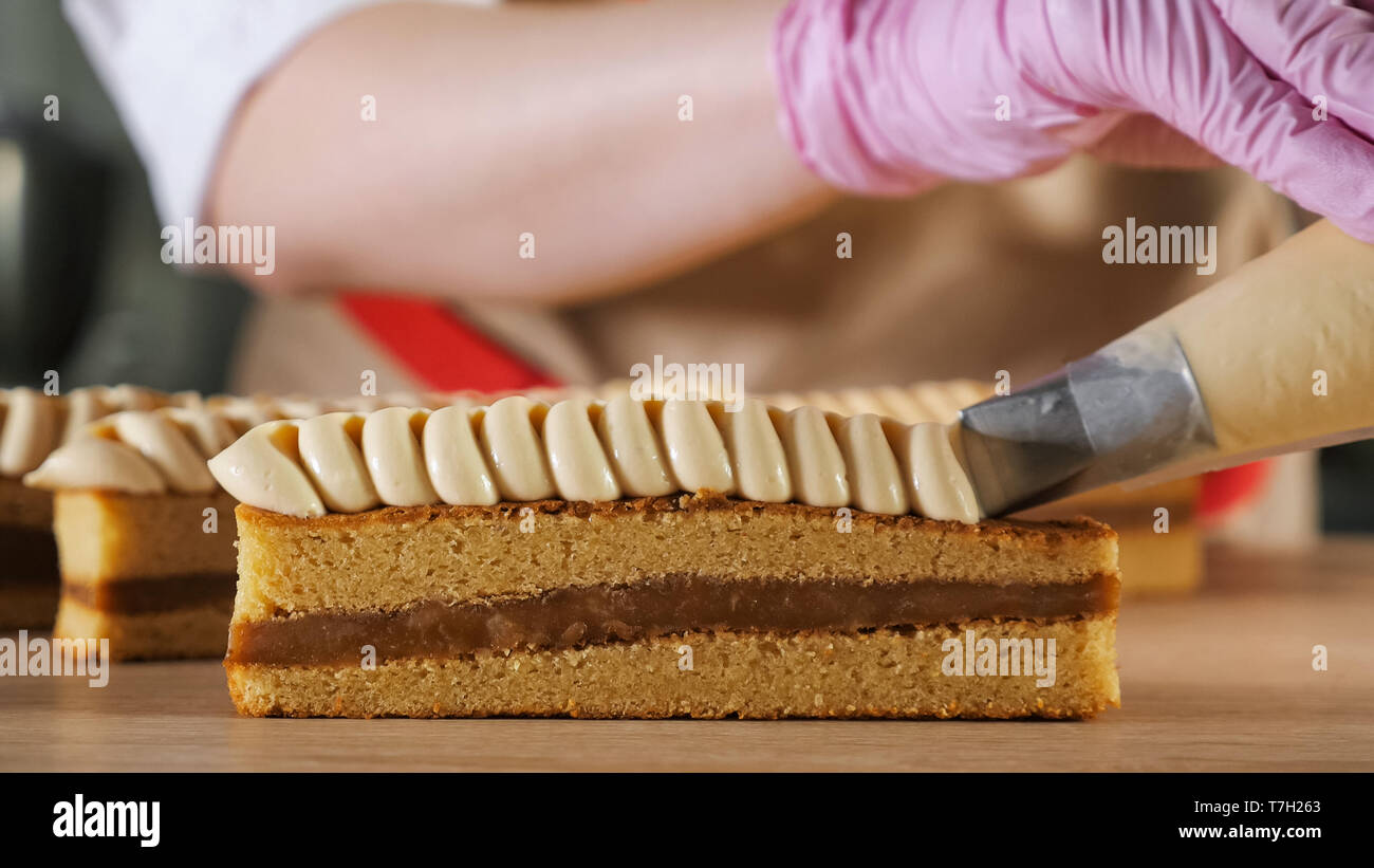 Chef Boulanger Decore Avec De La Creme De Biscuit Poche A Patisserie Mains De Pres La Cuisson Et La Production Alimentaire Industrielle Photo Stock Alamy