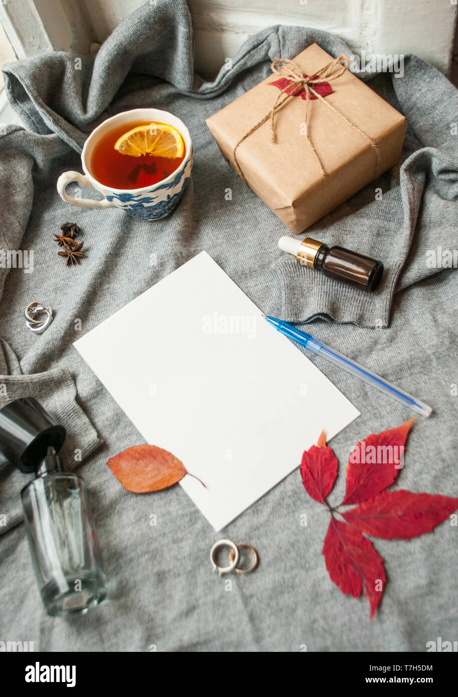 Belle tasse de thé au citron, et cértificat de différents accessoires sur fond tricoté gris . Automne-hiver confortable concept. Banque D'Images