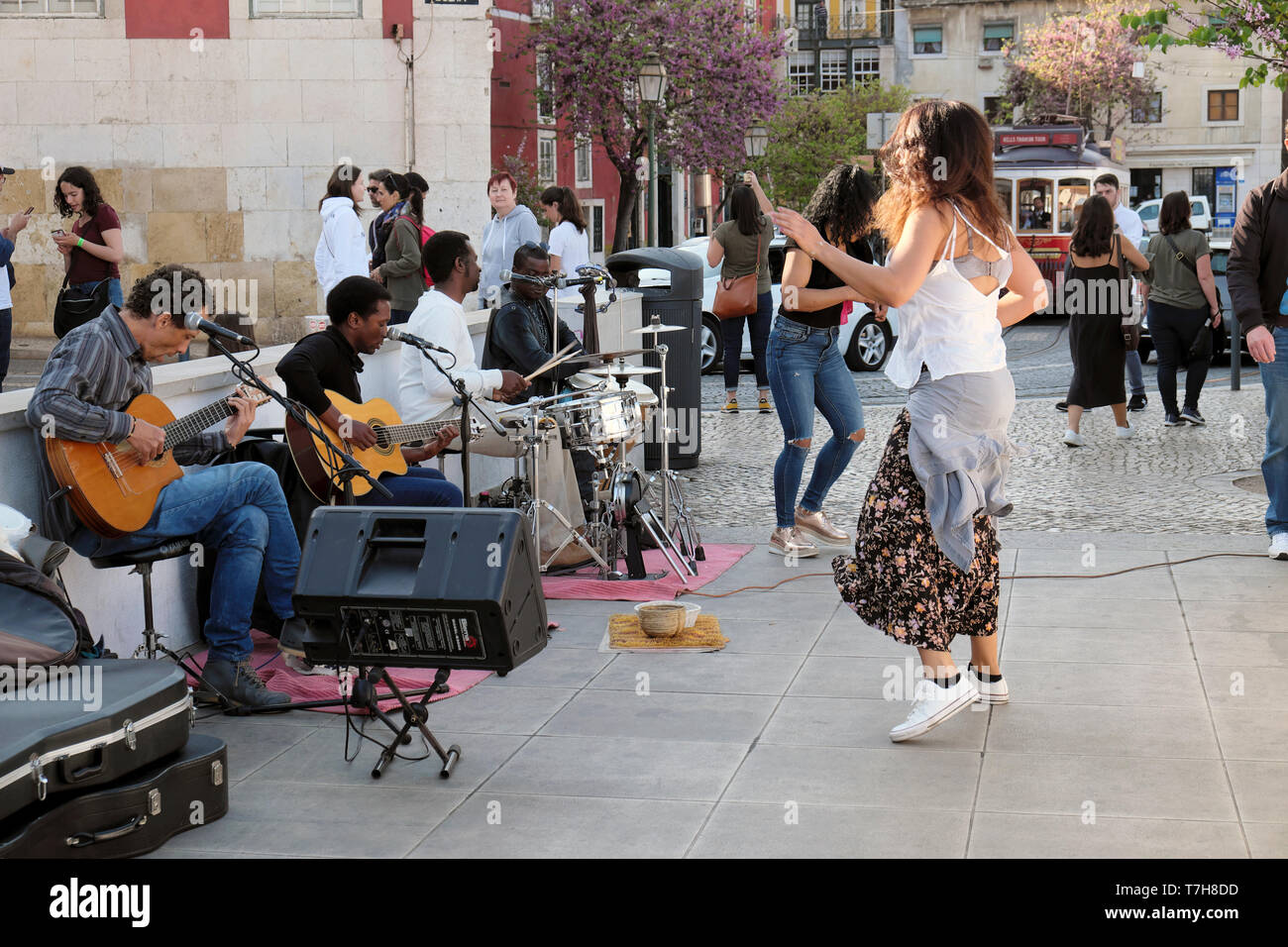 Les touristes watch femme dansant dans la rue à la musique d'un groupe de musiciens joueurs de guitare batterie d'Alfama de Lisbonne Portugal KATHY DEWITT Banque D'Images
