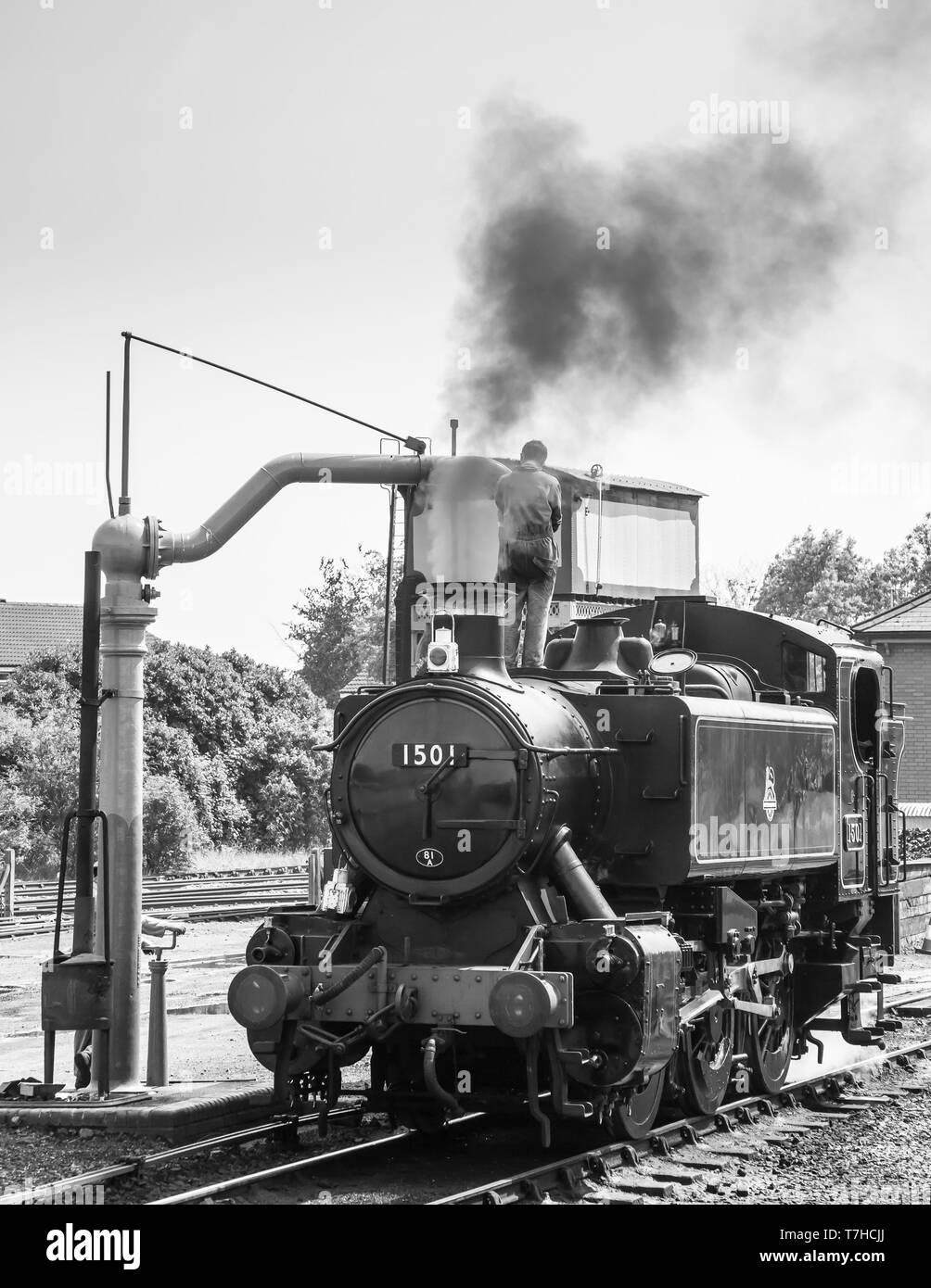 Locomotive à vapeur britannique vintage monochrome dans les sidings à la gare de Severn Valley Kidderminster prenant sur l'eau, train à vapeur équipage par grue d'arrêt d'eau Banque D'Images