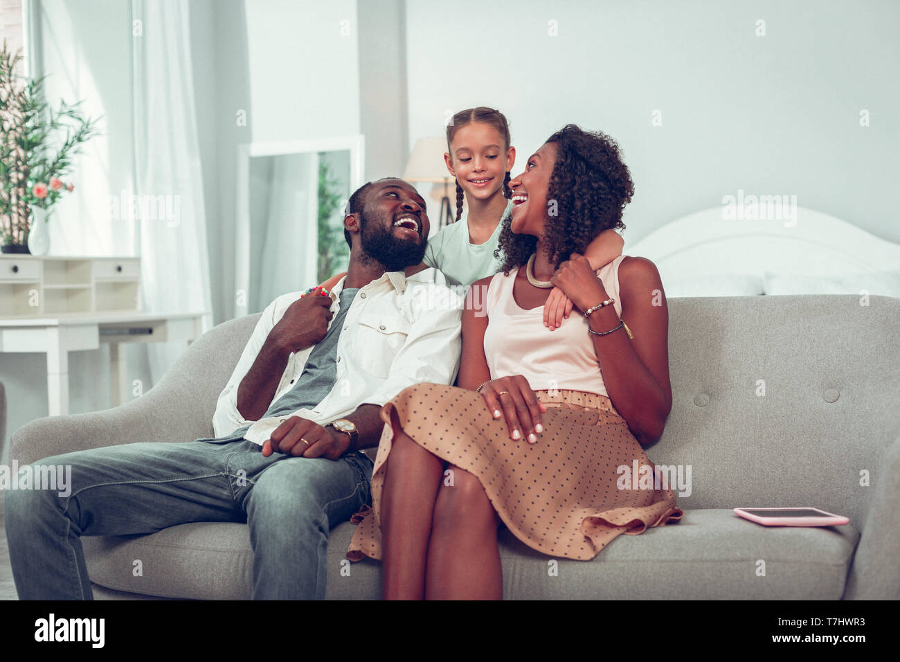 Happy smiling libre de trois assis sur le canapé Banque D'Images