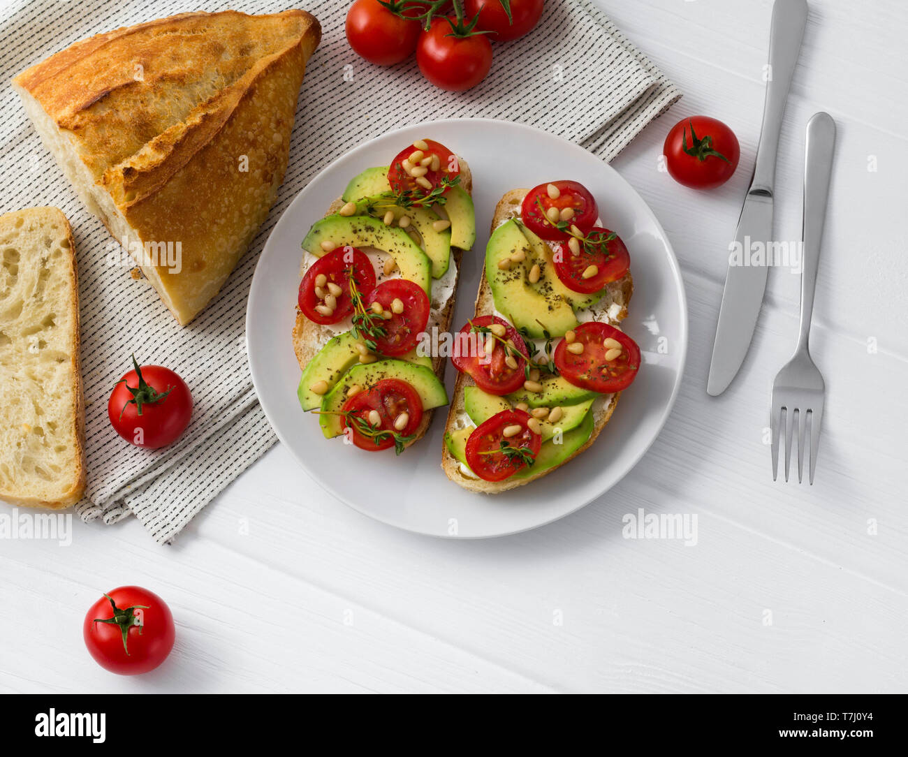 Deux sandwiches ou des tapas préparées avec des légumes différents,comme avocat, tomate et thym frais noix de pin étincelaient. Des aliments sains à la w blanc Banque D'Images