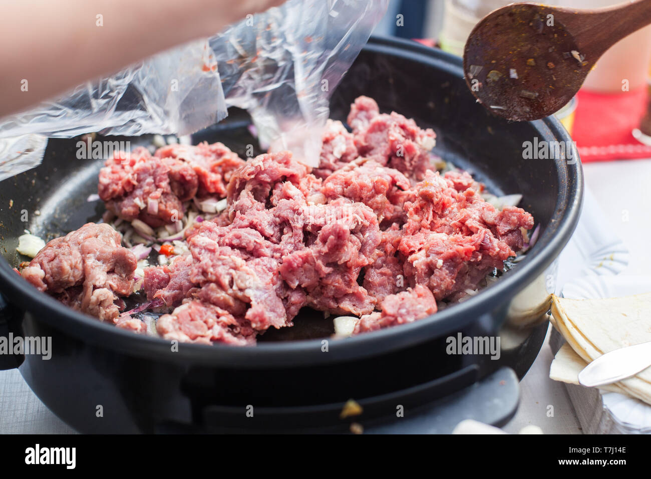 Close up de mettre la viande dans la poêle électrique Banque D'Images