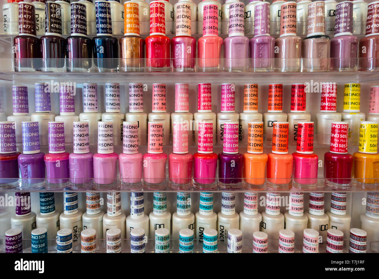 Bouteilles de vernis à ongles colorés sont soigneusement disposées sur sur  l'affichage sur des étagères dans un salon de manucure Photo Stock - Alamy