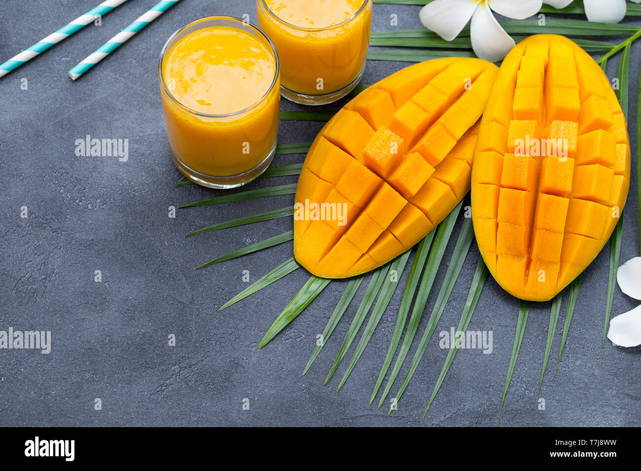 Smoothie aux fruits tropicaux frais et jus de mangue mangue fraîche sur fond gris. Copier l'espace. Banque D'Images