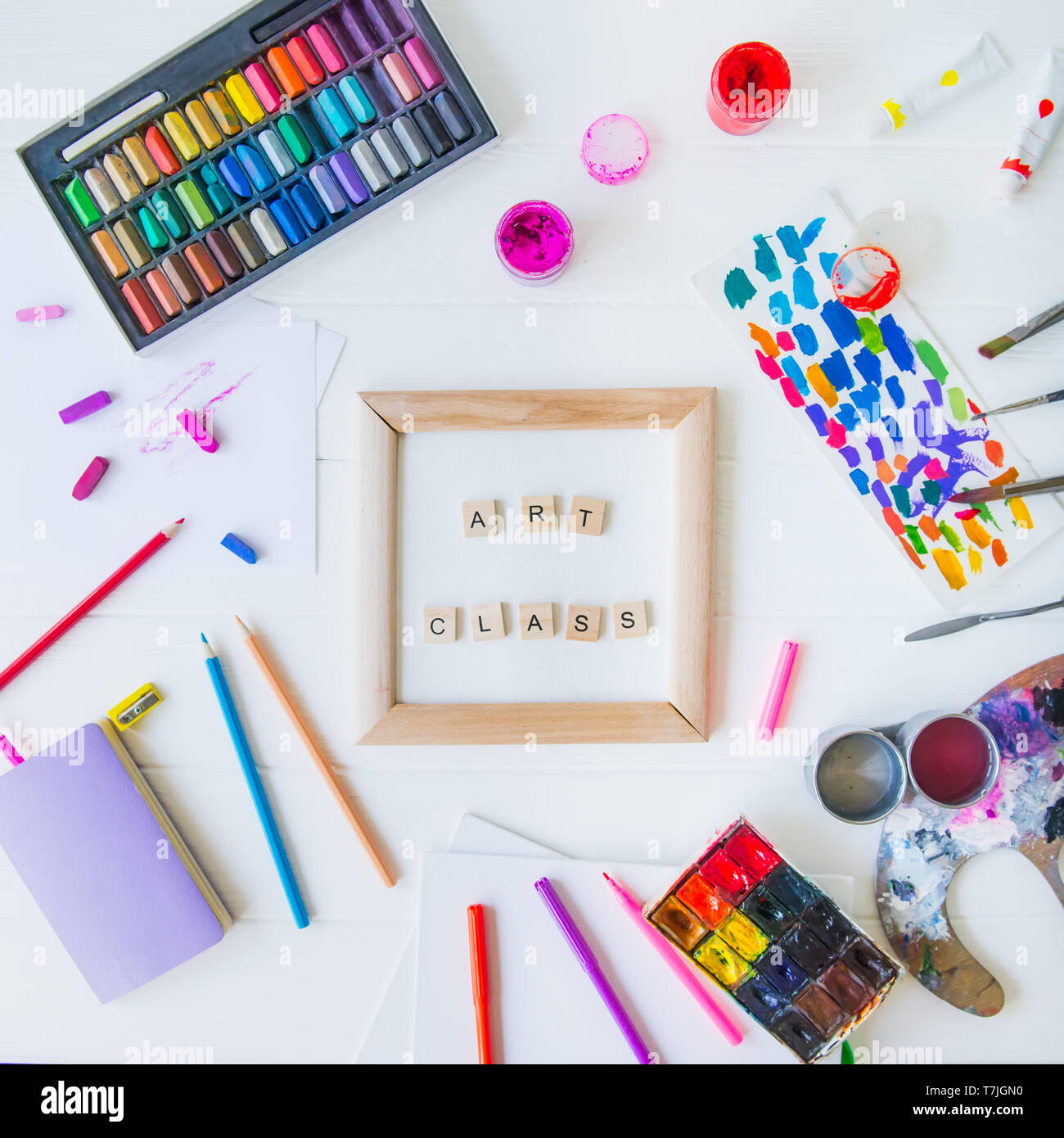 Vue supérieure de la classe d'art créative concept. Châssis en toile avec lettrage à l'intérieur et de nombreux matériaux colorés paintiing on white background. L Dessin Banque D'Images