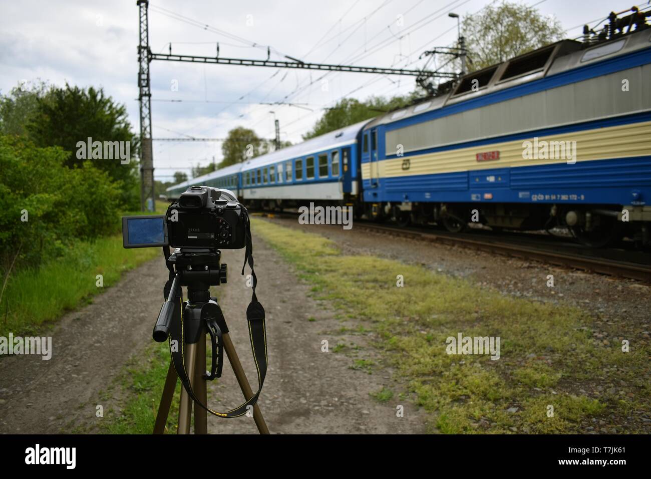 Se concentrer sur un appareil photo avec le passage des trains dans l'arrière-plan. Banque D'Images