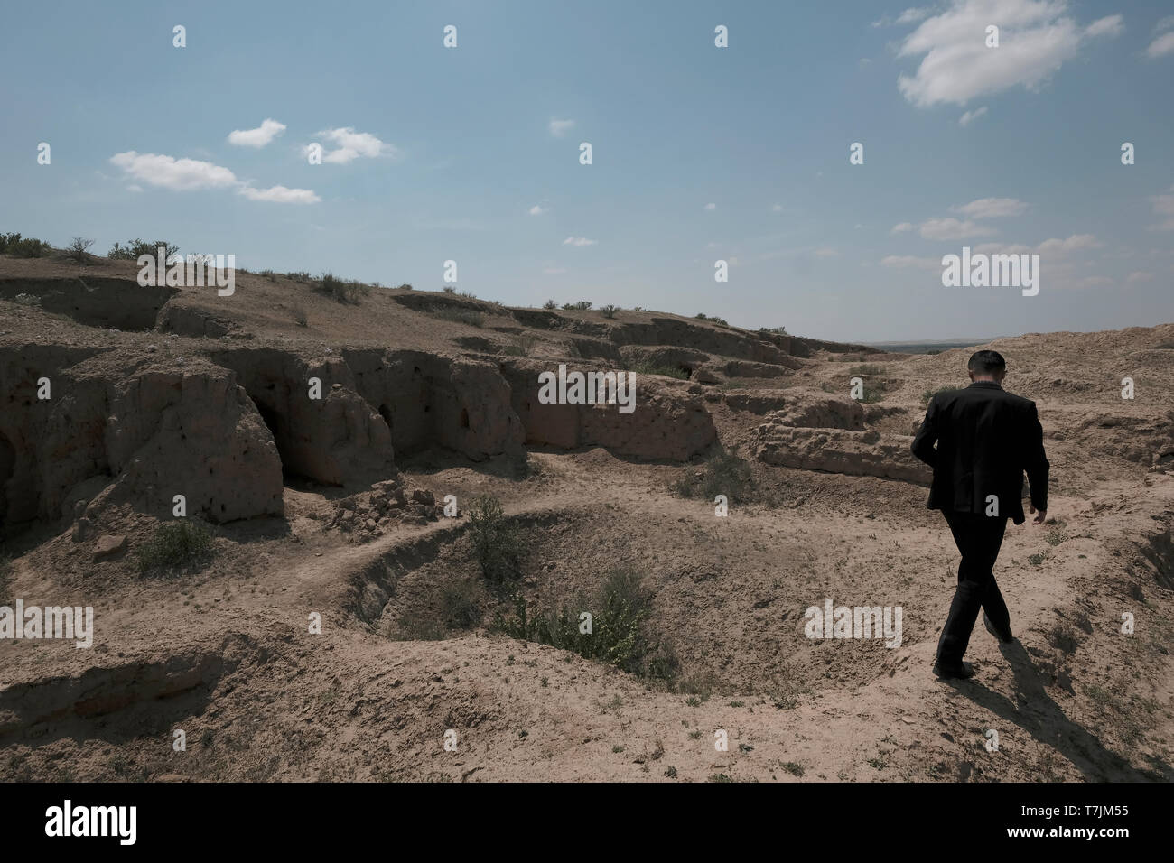 Un ouzbek se promène sur les vestiges de l'homme excavé fit des grottes en grès du premier au quatrième siècle ce au site archéologique de Kara Tepe, un complexe monastique bouddhiste construit sur trois collines près de la frontière avec l'Afghanistan et le Termez moderne dans la région de Surkhandarya ou Surxondaryo Ouzbékistan Banque D'Images