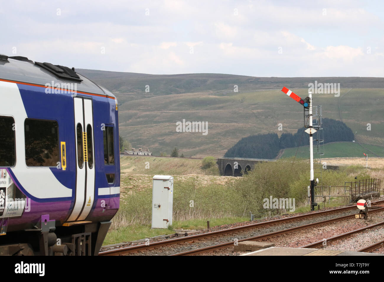 Train du Nord laissant à Garsdale station sur s'installer à Carlisle railway line signal sémaphore de passage le 30 avril 2019, Mire Dandry en viaduc vue. Banque D'Images