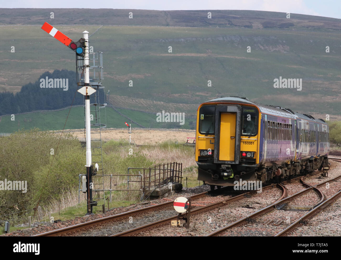 Train du Nord laissant à Garsdale station sur la ligne de chemin de fer s'installer à Carlisle signal sémaphore de passage le 30 avril 2019. Banque D'Images