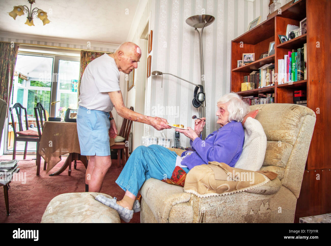 93 ans, homme, et avec l'état de coeur prend soin de ses gravement déficients visuels 90 ans femme prepaeres,cuisiniers et les repas et ne ménage pour elle. Banque D'Images
