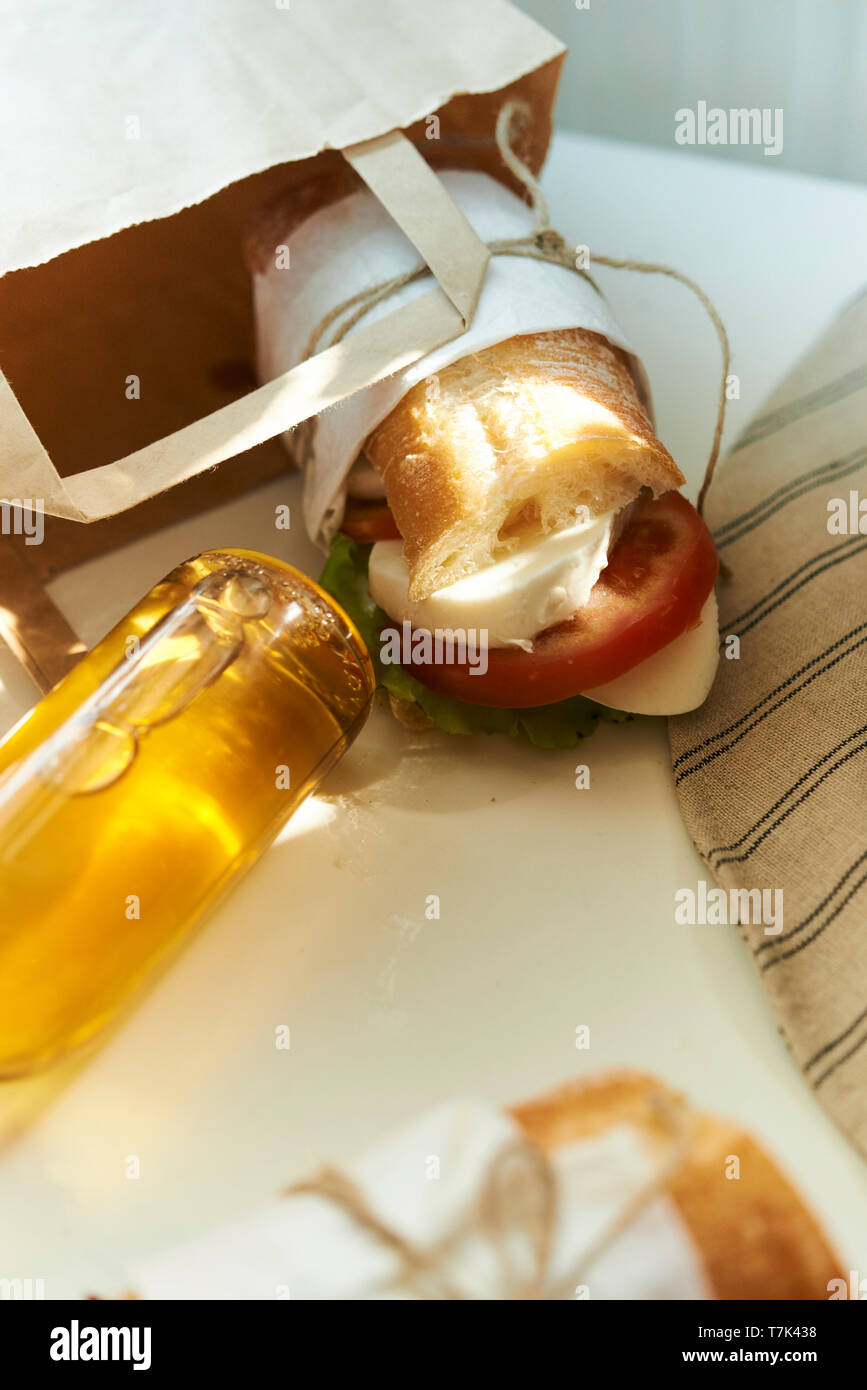 Sac de papier avec des sandwichs et bouteille de jus à jour d'été Banque D'Images