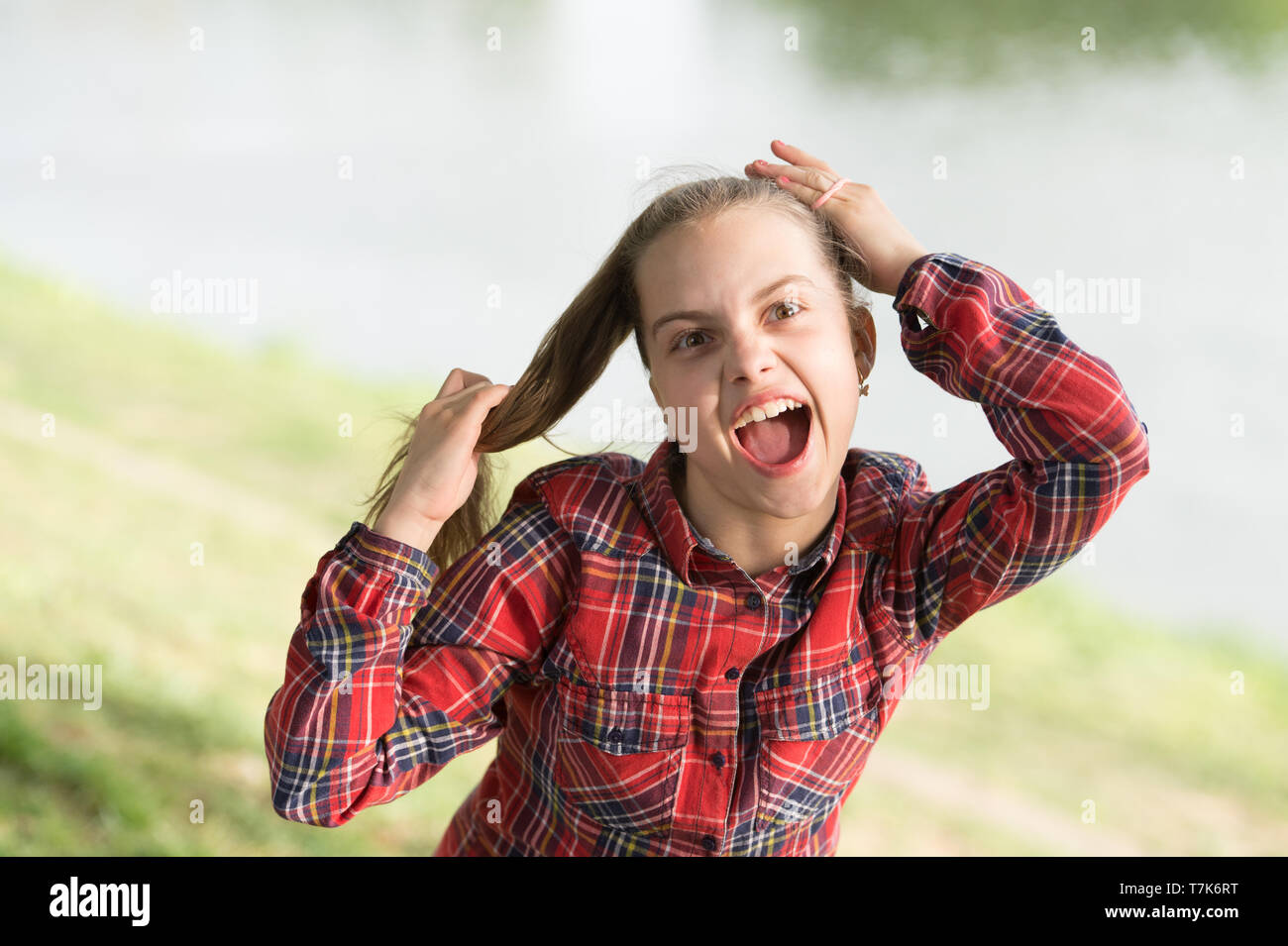 Traiter les cheveux longs sur jour de vent. Coiffures coupe-vent. Peu de fille cute child profitez à pied sur la nature de fond jour venteux. Coiffures à porter les jours de vent. Sentiment intime et confortable sur jour de vent. Banque D'Images