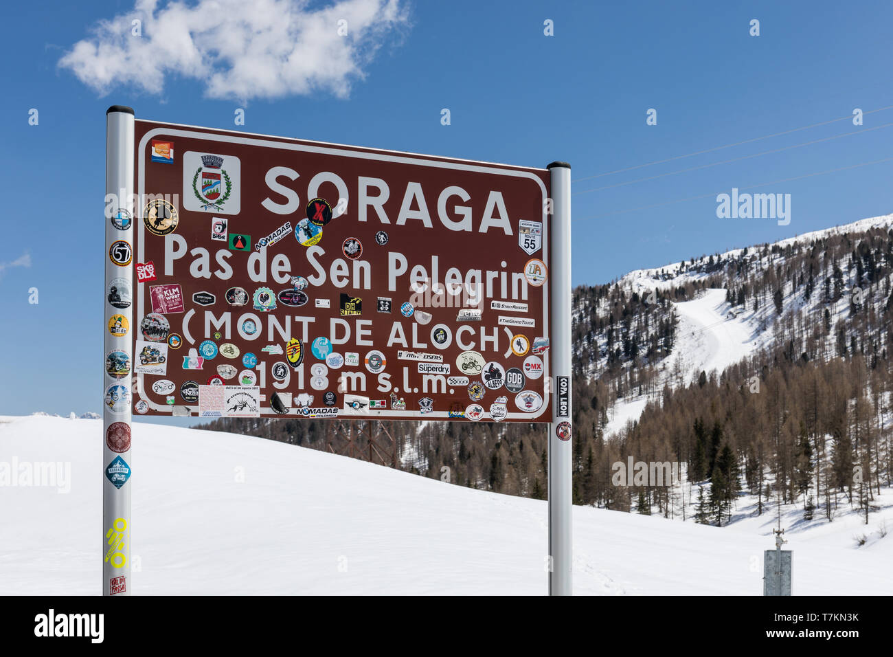 Panneau routier au Passo San Pellegrino couvert de visitors' autocollants - San Pellegrino Pass (ladin : Pas de Sen Pelegrín), Dolomites, Italie Banque D'Images