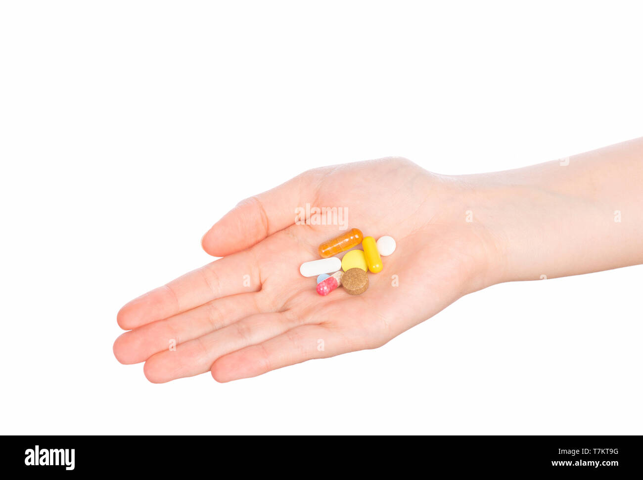 Comprimés dans la main femme isolé sur fond blanc. Woman hand holding pills on white Banque D'Images