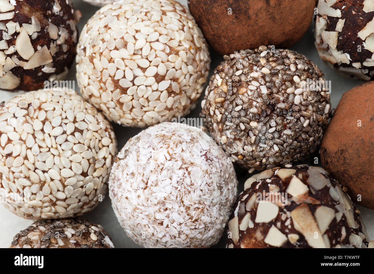 Boule d'énergie avec les fruits secs, noix, sésame, , ,flocons de noix de coco. Close up, macro,bonbons maison vegan.fond macro texture.focus sélectif. Banque D'Images